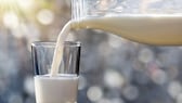 Milch aus einer Flasche in ein Glas