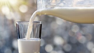 Milch aus einer Flasche in ein Glas