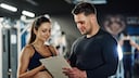 Frau und Mann tauschen sich im Fitnessstudio aus