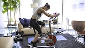 Frau im Home Gym mit Indoor-Bike