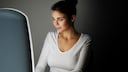 Frau sitzt vor Tageslichtlampe