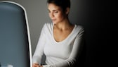 Frau sitzt vor Tageslichtlampe