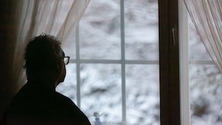 Ein Mann sieht nachdenklich aus dem Fenster