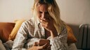 Frau mit Hypochondrie sitzt und schaut im Internet nach möglichen Krankheiten