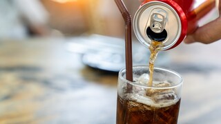 Jemand füllt Softdrink in ein Glas.
