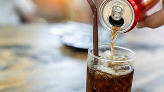 Jemand füllt Softdrink in ein Glas.