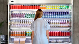 Eine Frau vor einem Kühlschrank mit Getränken