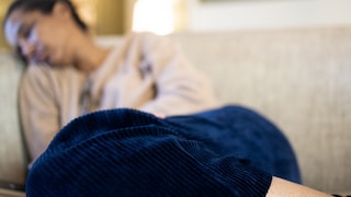 Long Covid Risikofaktoren: Müde Frau auf der Couch