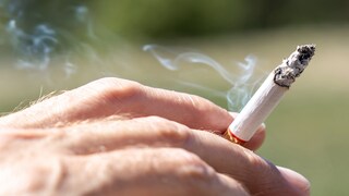 Zigarette Rauchen aufhören: Mann hält Zigarette in der Hand