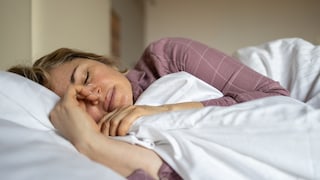 Perimenopause: Frau liegt im Bett