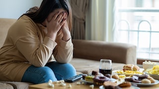 Unglückliche Frau vor ihrer Mahlzeit: Es gibt einen Zusammenhang zwischen fleischfreier Ernährung und der Wahrscheinlichkeit, eine Depression zu entwickeln