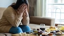 Unglückliche Frau vor ihrer Mahlzeit: Es gibt einen Zusammenhang zwischen fleischfreier Ernährung und der Wahrscheinlichkeit, eine Depression zu entwickeln