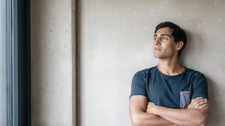 Hochfunktionale Depression: Mann schaut grübelnd Richtung Fenster