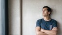 Hochfunktionale Depression: Mann schaut grübelnd Richtung Fenster