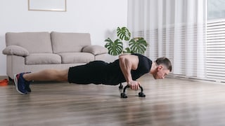 Ein Mann trainiert mit Liegestützgriffen