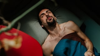 Mann liegt im Bett