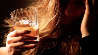 Alkoholismus: Frau mit Whiskey-Glas in der Hand