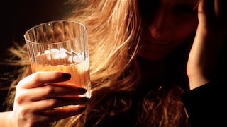 Alkoholismus: Frau mit Whiskey-Glas in der Hand