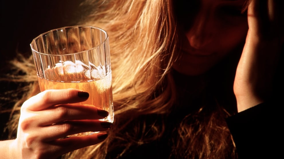 Alkoholismus: Frau mit Whiskey-Glas in der Hand