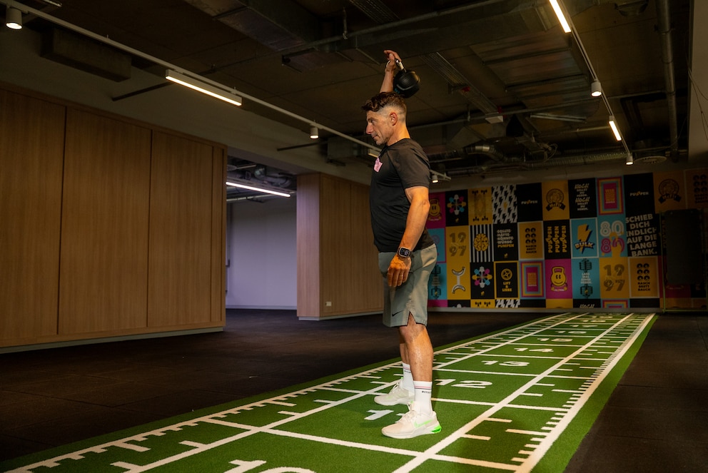 Beim Kettlebell-Snatch beugen Sie sich zun&auml;chst aus der H&uuml;fte nach vorn und f&uuml;hren die Kettlebell dann mit einer explosiven H&uuml;ftstreckung in einer flie&szlig;enden Bewegung bis &uuml;ber den Kopf.