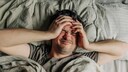 Clusterkopfschmerzen: Mann liegt im Bett
