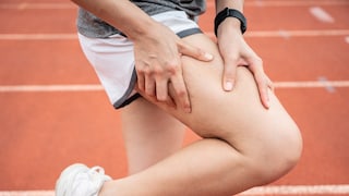 Person fasst sich an Oberschenkel