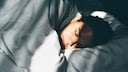 Mann liegt schlafend im Bett