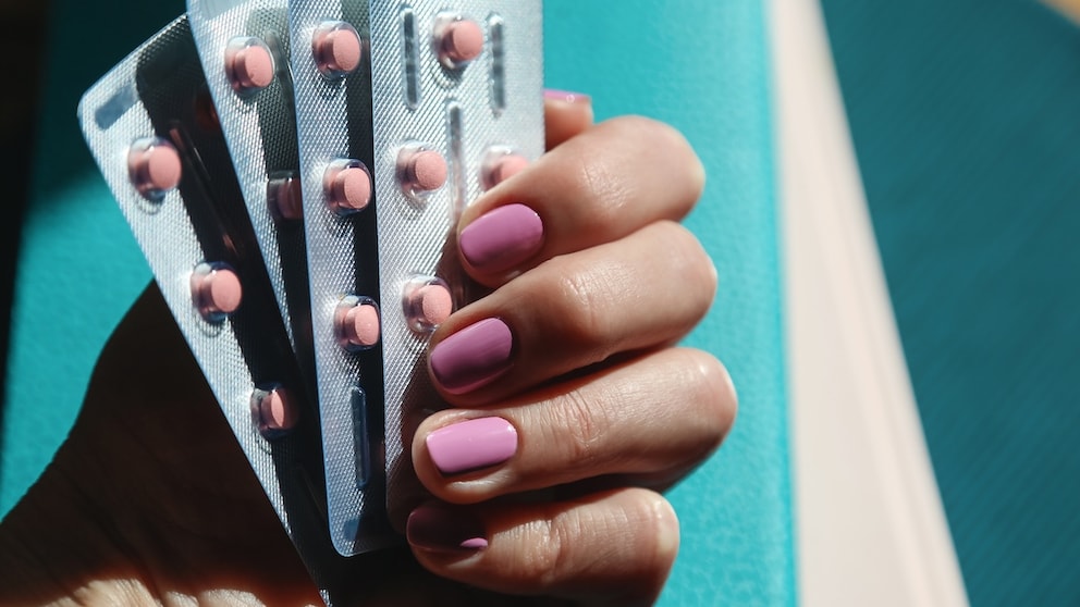 Verhütungsmittel im Kontext von Gehirntumoren untersucht: Frau hält Tabletten