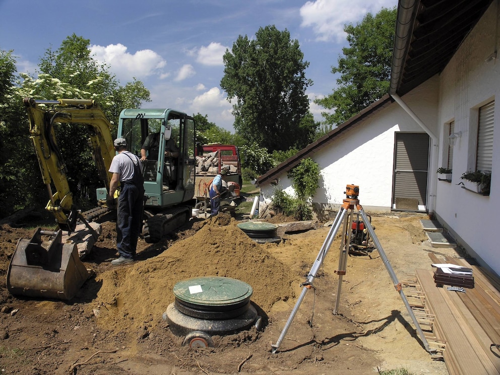 Regenwasser-Tanks werden vor einem Wohnhaus vergraben