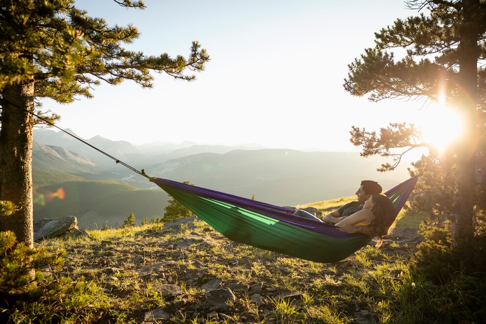 Paar relaxt in Hängematte mit Aussicht über Berge