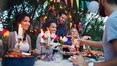 Menschen feiern am Abend eine Gartenparty