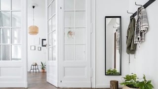 Ein heller Flur mit Garderobe und schmalem Spiegel