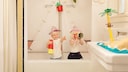 Zwei Kinder sitzen in einer Badewanne und spielen Bootfahren.