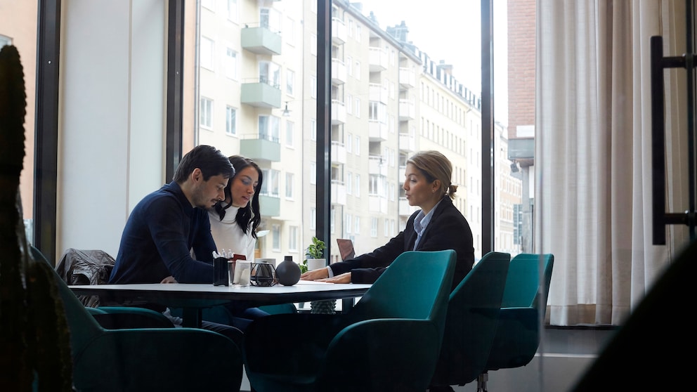 Ein Paar sitzt in einem Büro mit einer Beraterin