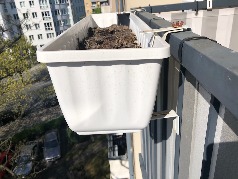 Mit einer Halterung lassen sich Blumenkästen am Balkon sichern