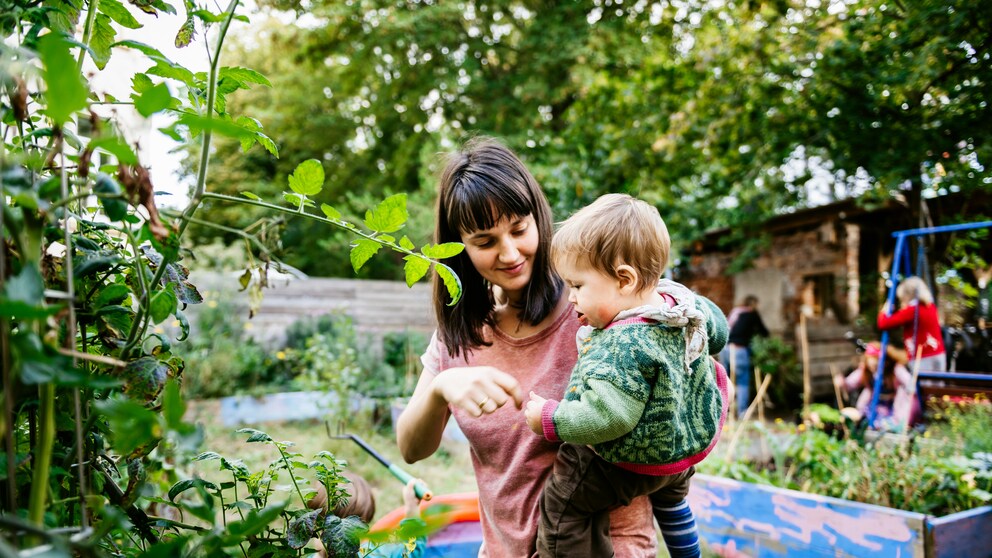 Mutter mit Kind im Schrebergarten