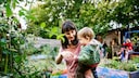 Mutter mit Kind im Schrebergarten