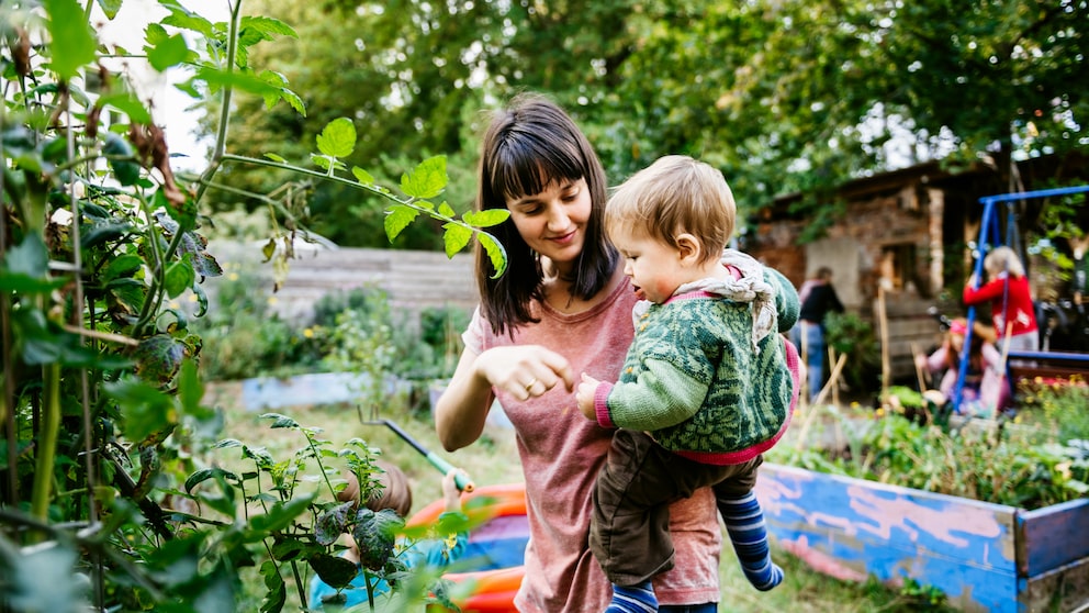 Mutter mit Kind im Schrebergarten