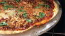 Pizza vom Grill mit einem Pizzastein