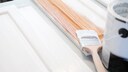 Ein Holzmöbel wird mit weißer Farbe lackiert