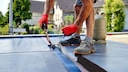 Ein Handwerker auf einem Flachdach