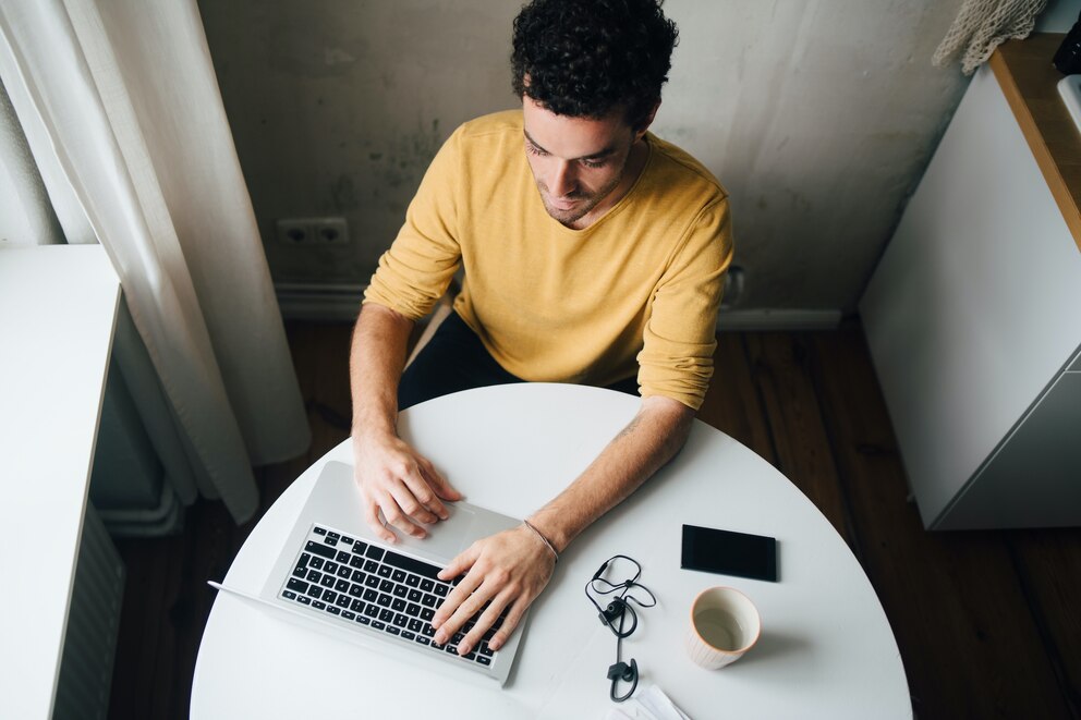 Mann sitzt an Laptop