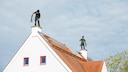 Zwei Schornsteinfeger arbeiten auf einem Dach