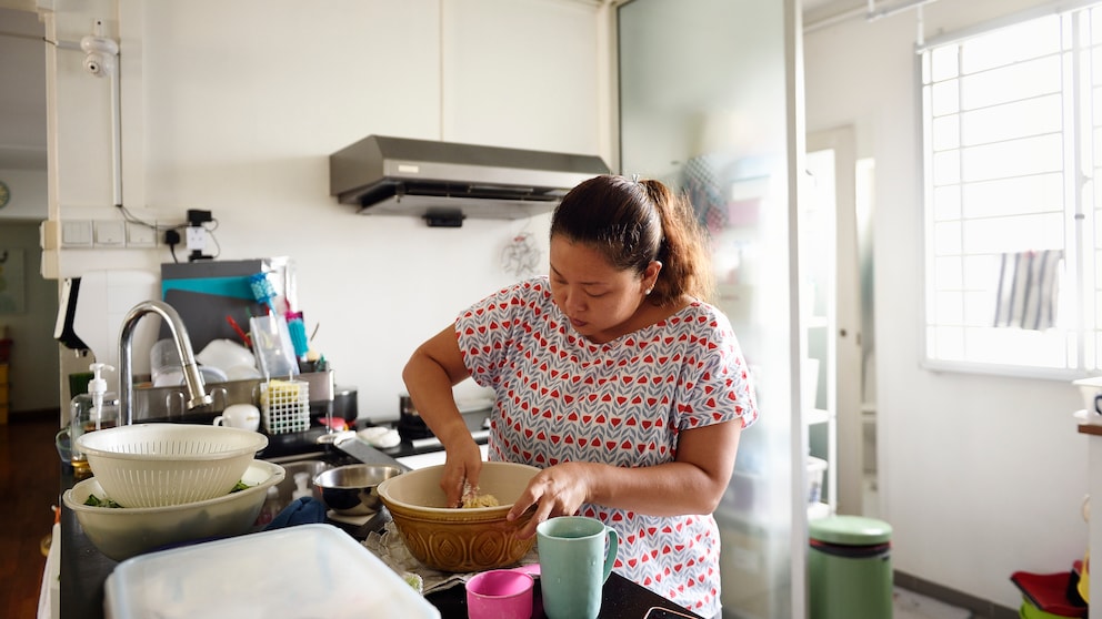 Eine Frau knetet Teig in der Küche