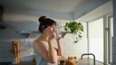 nachhaltige Alternativen im Haushalt: Eine Frau trinkt in der Küche einen Kaffee