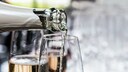 Warum perlt Sekt: In ein hohes Glas wird Sekt aus einer Flasche eingeschenkt