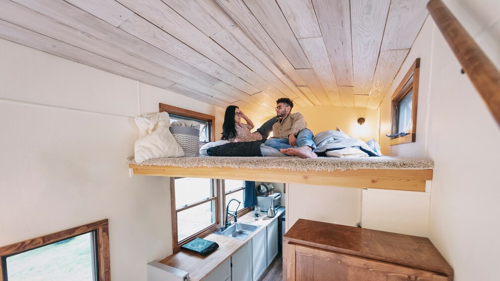 Micro-Living: Ein Paar liegt im Bett ihrem Tiny-House