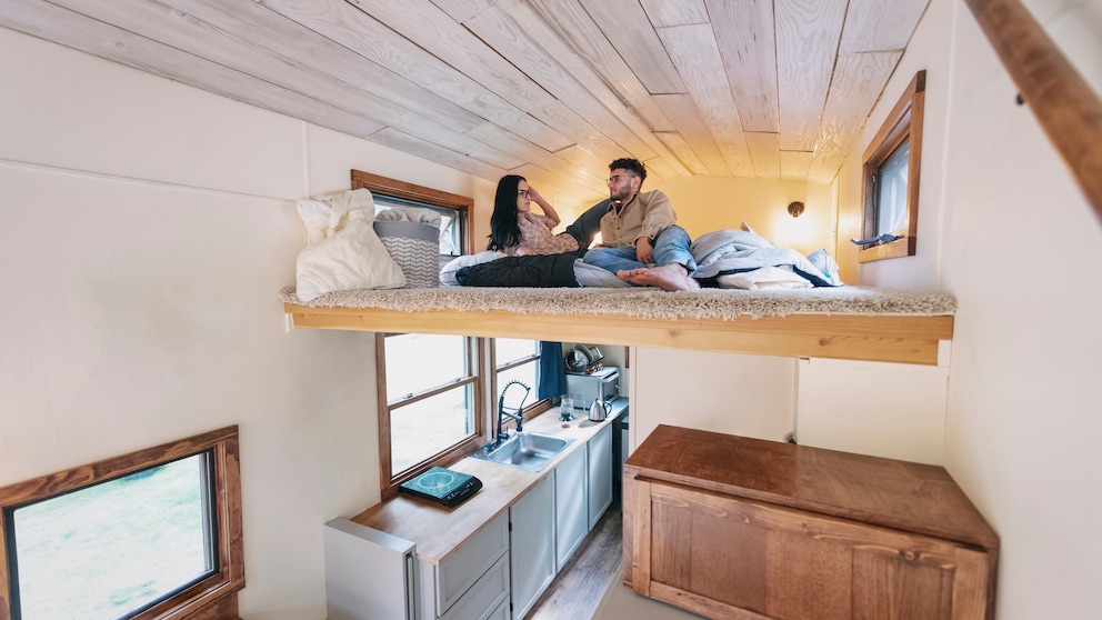 Micro-Living: Ein Paar liegt im Bett ihrem Tiny-House