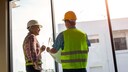 Zwei Bauarbeiter besprechen die Arbeit