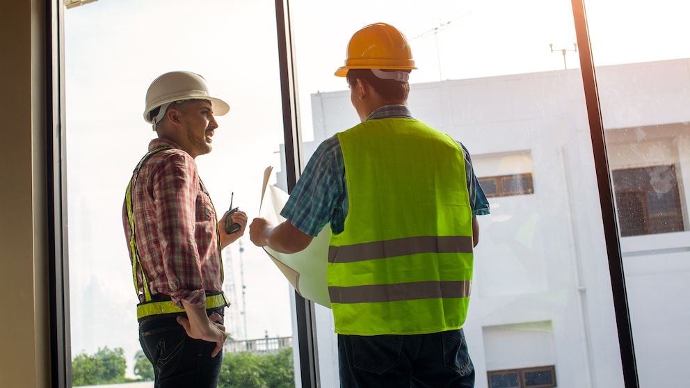 Zwei Bauarbeiter besprechen die Arbeit